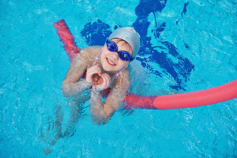 happy children kids group  at swimming pool class  learning to swim